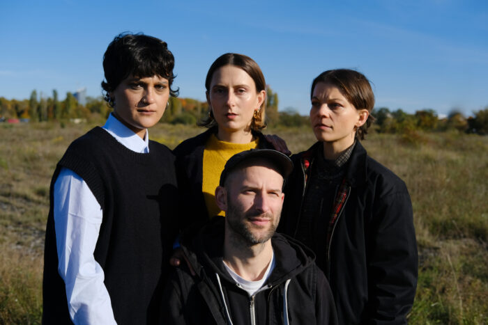 Man sieht vier Personen auf einer Wiese.