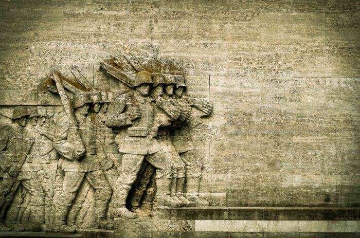 Aus Stein gehauene marschierende Soldaten auf einem Kriegerdenkmal