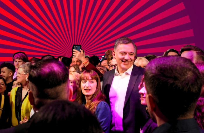 Heidi Reichinnek, Jan van Aken und andere Linkspartei Mitglieder im lila Licht, im Hintergrund ist sind lilarote Strahlen zu sehen