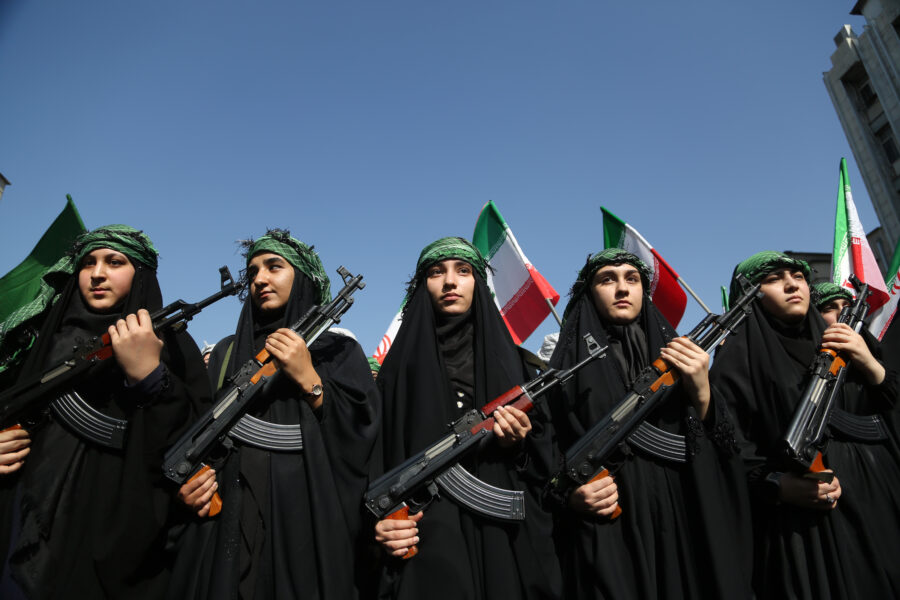 Frauen im Tschador mit grünen Halsbändern und Gewehren in der Hand