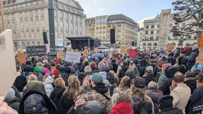Demonstrierende bei einem Protest in Hamburg in Solidarität mit Collien Fernandes. Unter anderem ein Schild mit der Aufschrift "Die Scham muss die Seiten wechseln" wird hochgehalten.