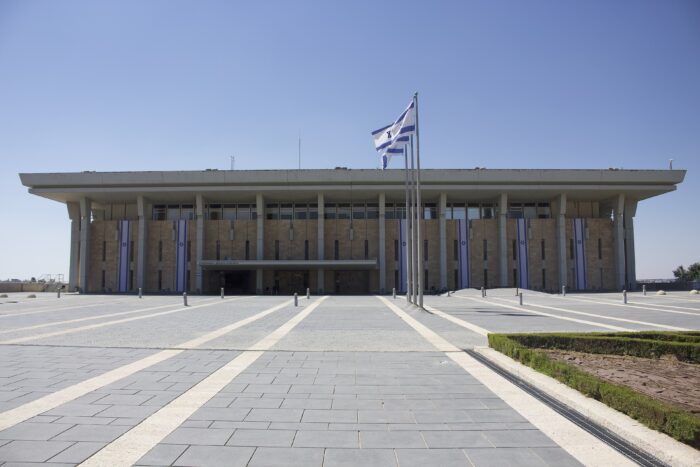 Gebäude der Knesset, aus dem die israelische Fahne herausragt.