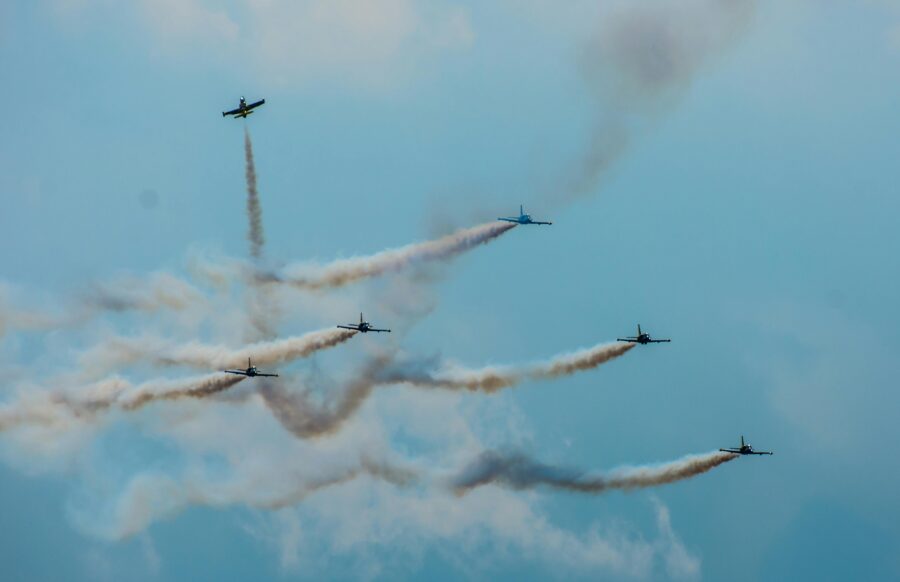 Das Bild zeigt mehrere Kampfjets bei einer Flugshow. Ein Jet scheint sich von der Gruppe zu trennen und allein in eine andere Richtung zu fliegen