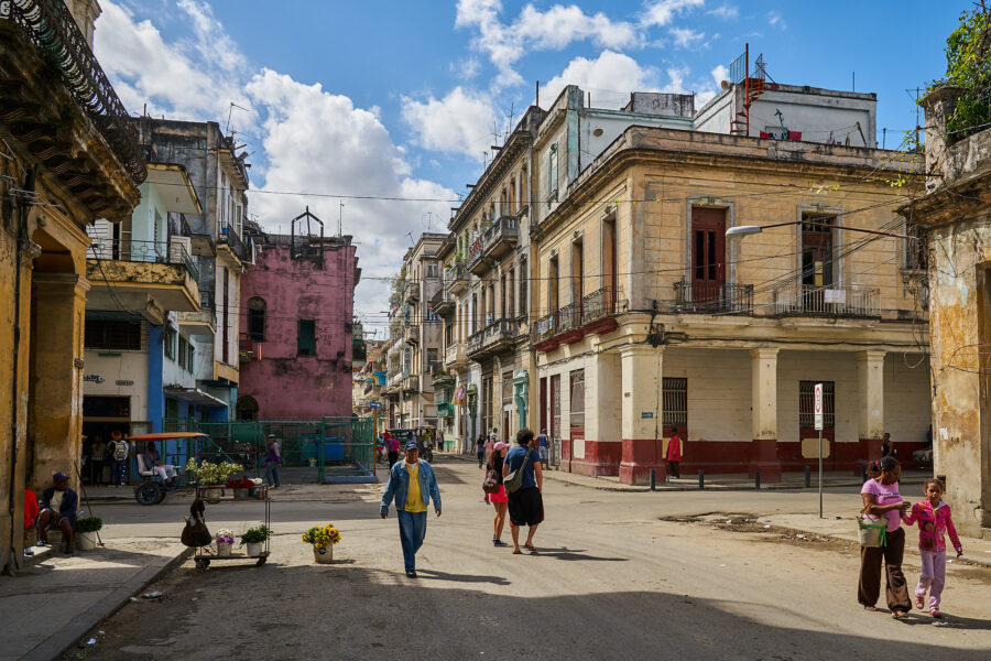 Bild einer Straßenkreuzung in Havanna, einige ältere Gebäude zeigen Verfallserscheinungen.