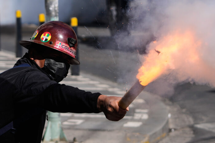 Ein Arbeiter mit einer Mundschutzmaske und einem Helm zündet ein Feuerwerkskörper
