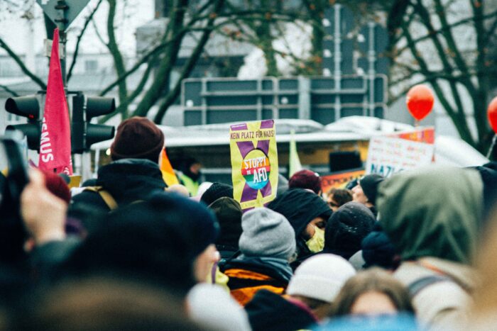 Menschenmenge mit einem Schild "Stoppt die AfD"