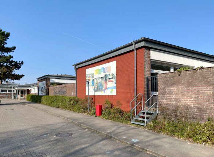 Foto eines Backsteingebäudes der Schule Kielkamp mit einem großen weißen Transparent an der Wand
